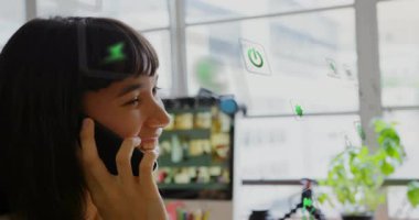 Masadaki akıllı telefonlara cevap veren kadın şeffaf pencerede beliren AR enerji simgelerini başlatıyor. Teknoloji, yenilik, sürdürülebilirlik, çevre dostu, dijital, modern, esnek