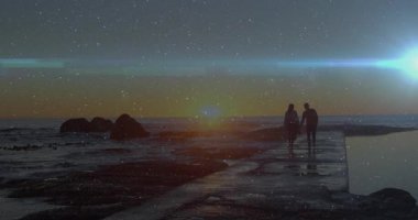 Gün batımında gökyüzünün altında el ele yürüyen bir çifti gösteren bir seyahat kampanyası. Yıldızlar beliriyor. Romantik, manzaralı, alacakaranlık, sükunet, macera, ufuk, siluet