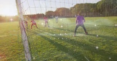 Kaleciden gol atmak için top ağlarına doğru süzülen bir yardımcı oyuncu geliyor. Spor, atlet, takım çalışması, yarışma, açık hava, eğlence, aksiyon