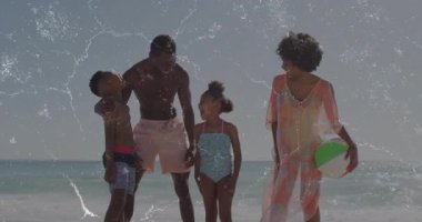 Baba, çocuklara sahilde ileri geri sallanan plaj topuyla pazarlama için rehberlik ediyor. Aile, sahil, tatil, açık hava, eğlence, mutluluk, birliktelik.