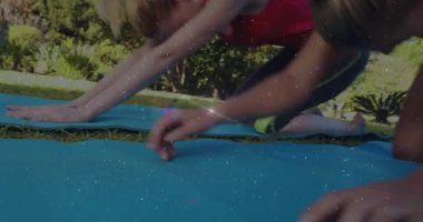 Yoga minderleri üzerinde diz çöken dört kadın gövdelerini öne doğru kaydırıyor ve fitness için geriye doğru kıvrılıyor. Fitness, sağlık, dinginlik, senkronizasyon, açık hava, doğal, birlik