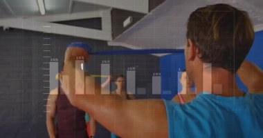 Stajyerler veri tablolarını yansıtırken, beden eğitimi eğitmeninin omuz kaldırma sinyali vermeye başlaması. Kuvvet, eğitim, takım çalışması, egzersiz, analitik, motivasyon, modern