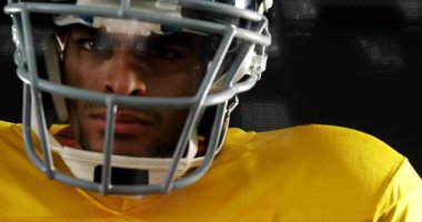 Sarı formalı futbolcu başını çeviriyor ve spor analizi için veri örtüsünü etkinleştiriyor. Sporcu, spor, teknoloji, analitik, eylem, rekabetçi, dinamik