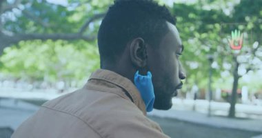 Adam kahve fincanına uzanıyor ve bir yudum alıyor, AR teknolojisi kullanarak bardağın etrafındaki animasyon ekolojik ölçümleri gösteriyor. Kentsel, çağdaş, yenilikçi, çevresel, sürdürülebilirlik, teknoloji, yaşam tarzı