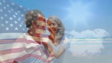 Kıdemli çift plajda vatanseverliği kutlarken şeffaf Amerikan bayrağı soluyor. Romantik, sahil, gün batımı, dinginlik, dostluk, sükunet, manzara