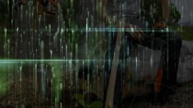 Arıza sonrası kereste işçisi, yeşil kod yoğunlaşırken balta tarama ormanıyla kütüğün üzerinde oturuyor. Doğa, vahşi doğa, dijital alarm, teknoloji, ormancılık, engebeli, açık hava