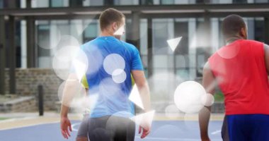 Basketbol topunu kaldıran, mavi gömlekli adam, savunma oyuncusuna karşı spor matkabında basket turnikesi için salya akıtıyor. Atletizm, takım çalışması, şehir sporları, aktif yaşam tarzı, rekabetçi, hareketli, canlı