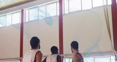 Kestane rengi basketbol oyuncusu pas alıyor ve basket atıyor. Beyaz defans oyuncusu çemberin yanında zıplıyor. Sporcular, takım çalışması, atletizm, rekabet, spor, eylem, dinamik