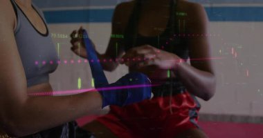 Antrenman partnerleri boks seansı için mavi el sargılarını açıyor ve bilek çevresindeki katmanları sıkılaştırıyor. Sporcular, fitness, dövüş sanatları, eğitim, güç, takım çalışması, dinamik