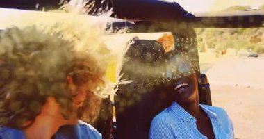 Sürücünün üstü açık arabadaki yolcuya baktığını altın kaplama süpürme ile gülerken gösteren bir seyahat reklamı. Macera, dostluk, boş zaman, açık hava, canlı, resimli, tasasız