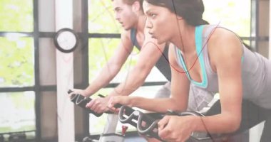 Jimnastik salonunda gidonu sürükleyen bisikletçiler cam pencerenin yanındaki kalp telleriyle senkronize pedalları başlatıyorlar. Fitness, dayanıklılık, takım çalışması, kardiyovasküler, motivasyon, eğitim, modern