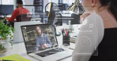 Meslektaşı el kol hareketi yaparken, elinde belge tutarken bilgisayarında iş görüşmesi yapan bir kadın. İşbirliği, dijital, teknoloji, iletişim, işyeri, üretkenlik, ofis