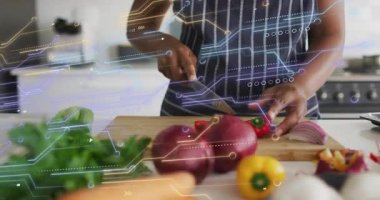 Ev aşçısı mutfak teknolojisini gösteren dijital kaplamanın altında biber dilimlemeye uzanıyor. Mutfak, gıda, uzmanlık, modern, canlı, yenilik, sağlık