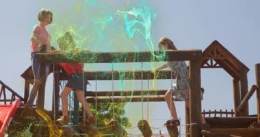 Zincir-kütük köprüsüne basan kız, teknolojiyi kullanarak yeşil-sarı enerjiyi aktive eden, takip eden arkadaşlar. Oyun alanı, çocuklar, macera, açık hava, enerji, arkadaşlık, etkinlik