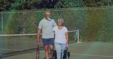 Maç bittikten sonra, spor çifti kol kola yürürken kamera yer değiştiren kort ışıklarını takip ediyor. Romantik, atletik, boş zaman, açık hava, arkadaşlık, aktif, klasik