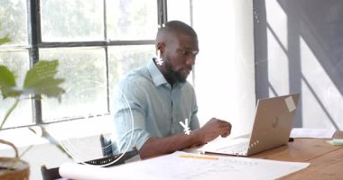 Tasarımcı planların üzerinde finansal semboller olarak yazmayı ve analiz etmeyi bitirir. Profesyonel, çalışma alanı, düşünceli, yeşil, modern, üretkenlik, planlama