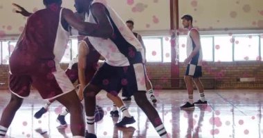 Basketbolda güvenli top, kestane renginde oyuncu smaç için defans oyuncularının yanından geçiyor. Atletizm, rekabet, takım çalışması, hareket, enerji, odak, spor