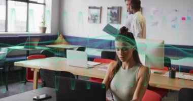 İş arkadaşları veri incelemesi sırasında yeşil klasörü dalga formuyla değiştirip masaları süpürüyorlar. İşbirliği, takım çalışması, veri analizi, modern ofis, profesyonel iletişim, dijital