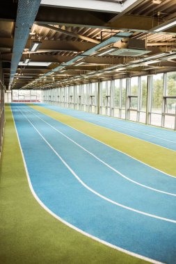 Empty blue running track in indoor stadium