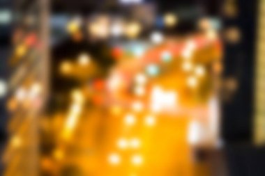 Şehirdeki aydınlanmış caddenin gece odaksız görüntüsü