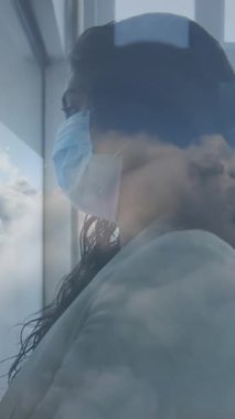 Mavi gökyüzündeki bulutlar, ofisteki beyaz tahtaya yüz maskesi takan Hintli kadına karşı. Coronavirus covid-19 salgını sırasında işyerinde hijyen ve sosyal mesafeler.