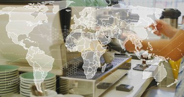 Barista in yellow shirt tamping portafilter in machine at cafe counter with tamper worldmap overlay. Coffee equipment, barista skills, beverage preparation, cafe interior, brewing process, professional tools, industrial design