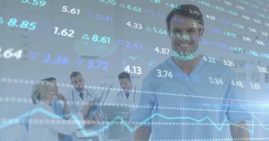 Standing smiling male doctor wearing light blue scrubs in clinic, with financial graph overlay. Medical team, healthcare, diagnostics, collaboration, analytics, professional, hospital