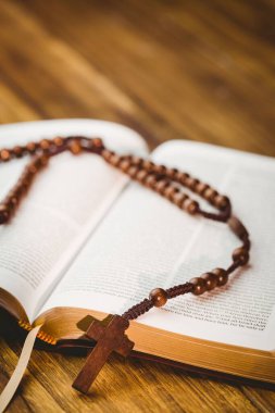 Close-up of rosary beds on bible book