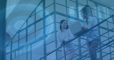 Ofis avlusunda dizüstü bilgisayar ve dijital arayüz grafikleriyle tartışan iki meslektaşım var. Yenilikçi, işbirliği, modernlik, profesyonellik, ağ, iletişim, teknoloji