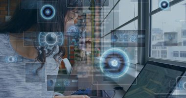 Çalışan kadın, dizüstü bilgisayarda şebeke penceresinin yanındaki ahşap masada HUD kaplamalı bir tişört giyiyor. Teknoloji, çalışma alanı, kentsel, yenilik, modern, dijital, iç mekan