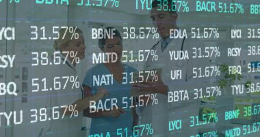 Hastane koridorundaki tablet ve steteskop verilerini analiz eden tıbbi ekibi inceliyorum. Sağlık, işbirliği, dijital, biyomedikal, takım çalışması, modern, klinik