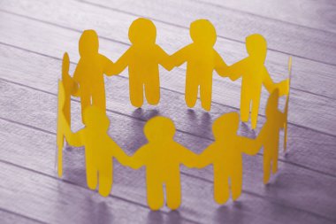 Tahta masadaki kağıt bebeklerin yüksek açılı görüntüsü