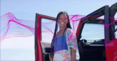 Kırmızı araçtan inen ve pazarlama için canlı pembe dalga grafiğini çalıştıran bir kadın. Canlı, enerjik, dinamik, boş zaman, açık hava, yaşam tarzı, modern