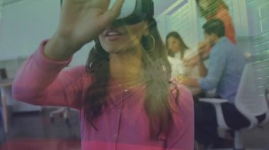 VR kulaklık takan ve iş birliği için arayüzü araştıran bir kadın, iş arkadaşları izliyor. Teknoloji, yenilik, işbirliği, fütürizm, profesyonellik, arayüz, takım çalışması