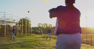 Atıcı beyzbolu sahaya çevirip bırakıyor, saha koşucusu eldivenle dalıyor. Atletizm, takım çalışması, aksiyon, açık hava, eğitim, canlı, rekabetçi