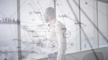 Erkek müdür, pencerenin yanındaki kahve fincanını kaldırıyor ve şehir manzarası üzerinde titreşen veri grafiklerini başlatıyor. Şirket, teknoloji, yenilik, analitik, modern, yönetici, kentsel