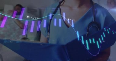 Hemşire grafikleri ayarlıyor, hasta akımı izlemek için kaydırma cihazı kullanırken tıbbi grafikleri kontrol ediyor. Tıbbi, sağlık, tanı, teknoloji, profesyonel, hasta bakımı, veri görselleştirmesi