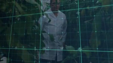 Kamera izleme şebekesi, erkek araştırmacıların sera ürünlerini izlerken yaprakları ittiğini gösteriyor. Botanikçi, bahçıvanlık, biyoteknoloji, fütürist, bilimsel, kapalı tarım, araştırma