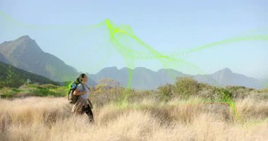 Yetişkin bir kadın yürüyüşçü çimlere basıyor ve tepeleri haritalamak için neon teknolojisini devreye sokuyor. Macera, keşif, vahşi doğa, teknoloji, yenilik, açık hava, yürüyüş
