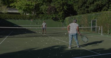 Özel tenis kortunda duran tenis çifti, taşaklı raketler ve metal kapılar tutan. Atletik, boş zaman, açık hava, spor, rekabet, enerjik, yaşam tarzı