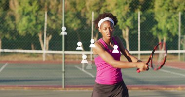 Pembe bluzlu bir tenisçi, tenis kortunda raket ve çitle ters vuruş hazırlıyor. Atletik, spor, yarışma, fitness, açık hava, canlı, kararlı