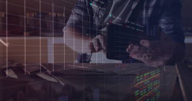 Orta yaşlı bir adam, kareli gömlekli, masada tablet tıkırdatıyor, hisse senedi verileri örtüşüyor. Teknoloji, finans, veri, analitik, üretkenlik, profesyonel, modern