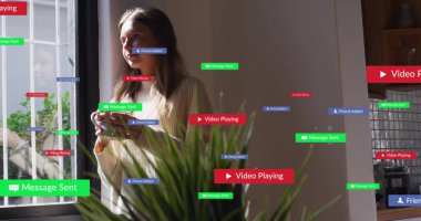 Akıllı telefonlu kadını evde tutmak, havada süzülen mesaj, iletişim ve medya etiketlerini göstermek. Çağdaş, içsel, minimalist, dijital, iletişim, yaşam tarzı, rahatlama