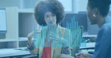 Ceket giyen kıvırcık saçlı bir kadın ofiste monitörlerle veri örtüsünü açıklıyor. İşbirliği, iletişim, takım çalışması, analitik, teknoloji, üretkenlik, modern