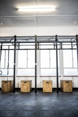 Aydınlatılmış spor salonundaki kutuların yanında jimnastik halkaları