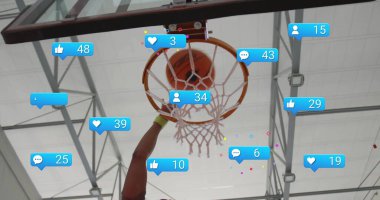 Yüzen sosyal medya simgeleriyle basketbol topunu saha çemberine sokup smaç basan basketbolcu. Sporcu, rakip, dinamik, aksiyon, spor, adrenalin, yüksek enerji