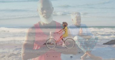 Kırmızı atlet giyen siyah bir adam plajda dua ediyor, pembe bisiklet süren bir kadınla. Spiritüellik, dinginlik, farkındalık, refah, rahatlama, rahatlık, canlılık.