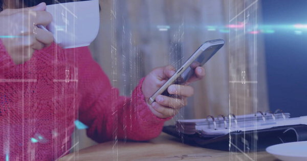 Держа кружку, женщина в красном свитере прокручивает смартфон за деревянным столом, с ноутбуком, копировальным местом. Отдых, городской, винтаж, технологии, комфорт, уют, производительность