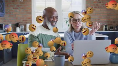 Dizüstü bilgisayardaki mali durumları inceleyen çift, dönen 3D emoji renklendirme işbirliğini tetikliyor. Ortaklık, iletişim, yenilik, teknoloji, dijital, takım çalışması, modern