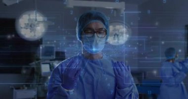 Erkek cerrah eldivenli ellerini AR ekranına kaldırarak ameliyattan önce holografik veri ızgarasını ayarlıyor. Tıbbi, teknoloji, yenilik, fütüristik, sağlık, kesinlik, klinik